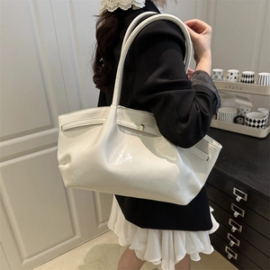 Large white glossy patent leather tote bag for women shown from a model's back view