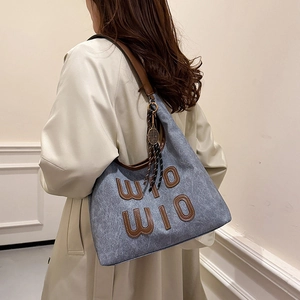 Sac fourre-tout gris-bleu avec brides en cuir et écusson WIO WIO porté par un mannequin