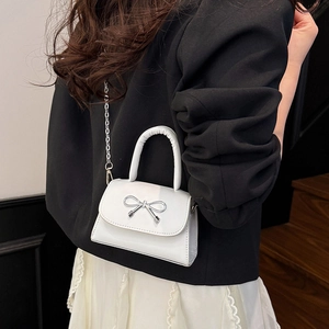Chic white minimalist crossbody bag with silver bow accent and thin chain strap for women