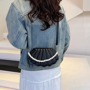 Sac bandoulière chic noir en forme de coquille avec chaîne de perles sur un modèle