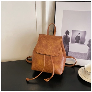 Detail view of caramel brown drawstring backpack with textured vintage synthetic leather