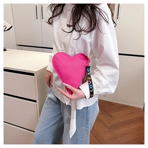 Detail of fuchsia heart-shaped leather bag with a colorful LOVE letter strap