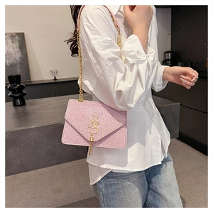 Detailed shot of pink sequined envelope bag with gold SS buckle and fringe tassel detail