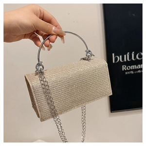Detail van champagne goudkleurige pailletten tas met zilveren ronde handgreep en ketting