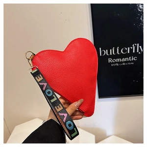 Detail of red heart-shaped leather bag with LOVE letter webbing strap and gold hardware