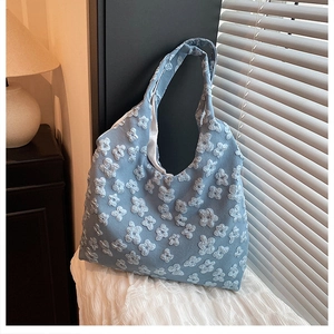 Dettaglio della borsa hobo azzurra con trama floreale 3D e motivo in tessuto goffrato