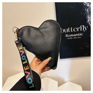 Detail of black heart-shaped clutch with lychee pattern leather and LOVE strap