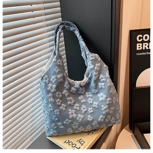 Dettaglio della borsa tote azzurra con ricami floreali 3D e tessuto strutturato