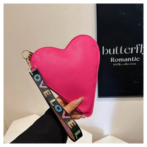 Detail of fuchsia heart-shaped handbag with lychee texture leather and LOVE embroidered strap