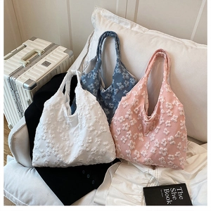 Detailed texture of tote bags with 3D floral patterns in white, blue, and pink
