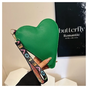 Detail of bright green heart-shaped bag featuring lychee grain leather and LOVE strap
