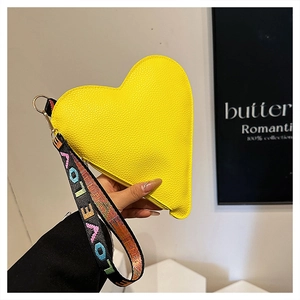 Macro shot of yellow heart-shaped clutch bag with lychee grain texture and LOVE wristlet