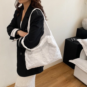 Borsa tote bianca con trama floreale 3D e grande capacità indossata da una modella