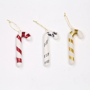 Three festive Christmas candy cane ornaments in red, gold, and silver hanging on gold strings