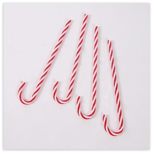 Close-up of four red and white spiral candy canes for Christmas tree decoration