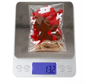Detailed view of 13.2g Christmas felt ornaments set being weighed on a digital scale