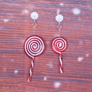 Lecca-lecca decorativi natalizi rossi e bianchi su fondo in legno rustico con effetto neve