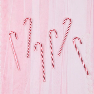Set of 6 red and white striped Christmas candy cane ornaments on a pink background