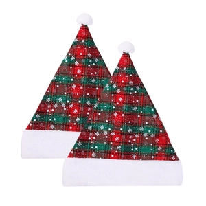 Detail of red and green plaid Christmas hats with snowflake print and plush white trim