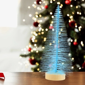 Close-up of a light blue mini artificial pine tree with a round wooden base for Christmas