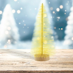 Close-up of a yellow mini sisal Christmas tree with a natural wooden base on snow