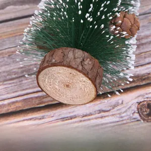 Close-up of natural wood base texture and frosted pine needles on mini Christmas tree