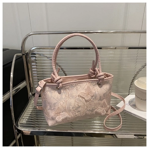 Detail of light pink lace handbag with 3D butterfly appliques and leather handle