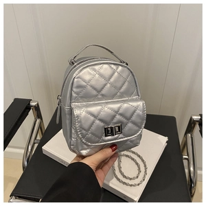 Close-up of silver quilted mini backpack with metallic finish and metal turn-lock closure