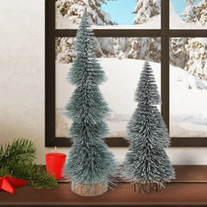 Mini artificial frosted cedar trees with wooden bases set against a snowy window view