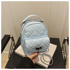 Detailed view of the light blue quilted mini backpack with silver metal chain and twist lock