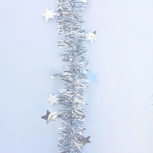 Detail of silver Christmas tinsel garland with shiny stars on a light blue background