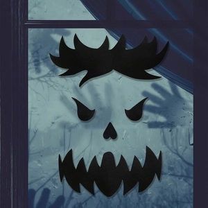 Detail of Halloween monster face window decals with scary eyes and fangs on wet glass