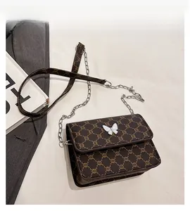 Detail of monogram flap bag with white butterfly buckle and metal chain strap