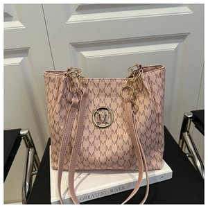 Detail of pink monogram tote bag with gold M logo and chain strap on books
