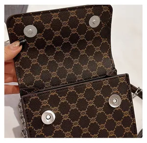 Detail showing two silver magnetic snaps and brown monogram pattern on the handbag