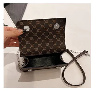 Detail view of the open dark brown chain bag showing internal storage and magnet closures