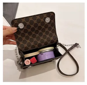 Internal view of brown monogram chain bag showing space for cosmetics and lipstick