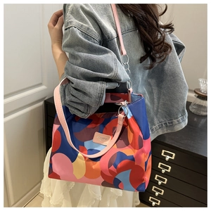 Detail of colorful pop art shoulder bag with metal rings on blue denim outfit