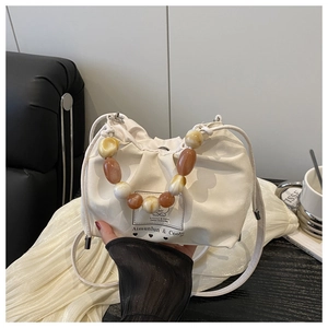 Detail of white wrinkled leather bucket bag with marble bead handle and printed logo