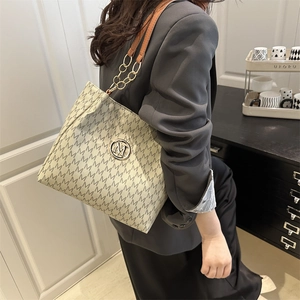 Chic beige tote bag with M-letter monogram and golden chain strap shown on model