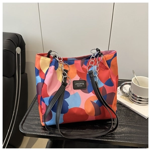 Detail of colorful geometric pattern tote bag with leather and metal chain straps