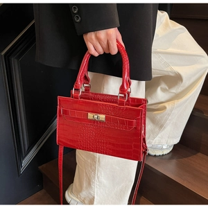 Detail of red crocodile pattern PU leather handbag with metallic rotating buckle