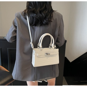 Rear view of a white crocodile embossed handbag on a model for modern styling