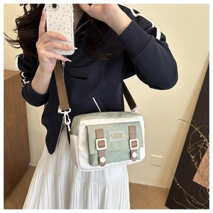Mirror selfie showing the small green and white canvas crossbody bag for women