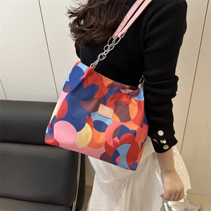 Colorful geometric patchwork underarm bag with chain strap and brand logo patch