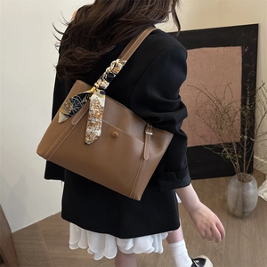Brown leather tote bag for women with decorative silk scarf and white stitching detail