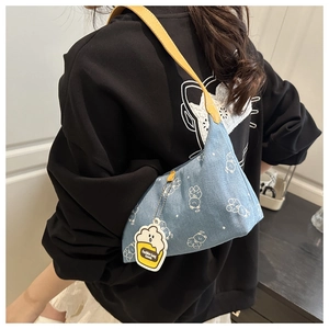 Détail du sac à bandoulière en denim bleu avec motifs ours blancs et sangle jaune