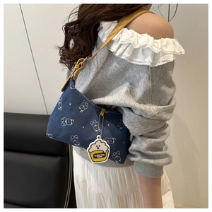 Détail du sac carré en denim bleu avec imprimé ours et pendentif en forme de tasse