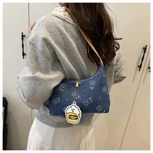 Détail du sac à épaule en denim avec imprimé ours et breloque cupcake mignonne