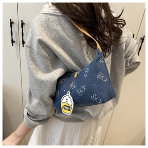 Détail du sac hobo en denim bleu foncé avec oursons blancs et fine bandoulière jaune